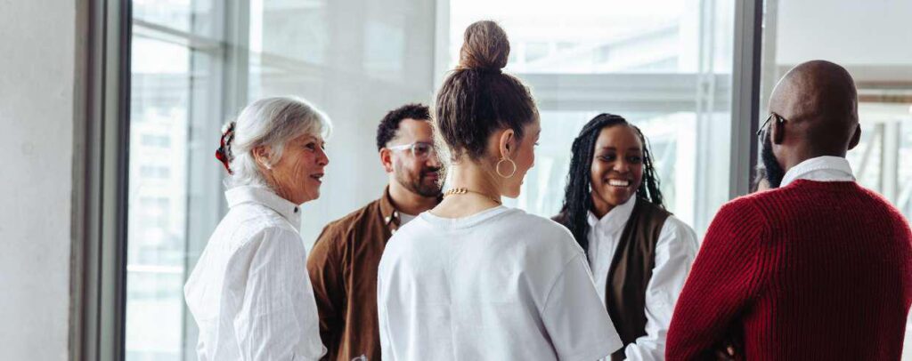 a group of diverse people in terms of gender and race talking in a meeting